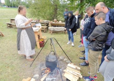 Wychowanki słuchają wykładu przed stoiskiem archeologicznym